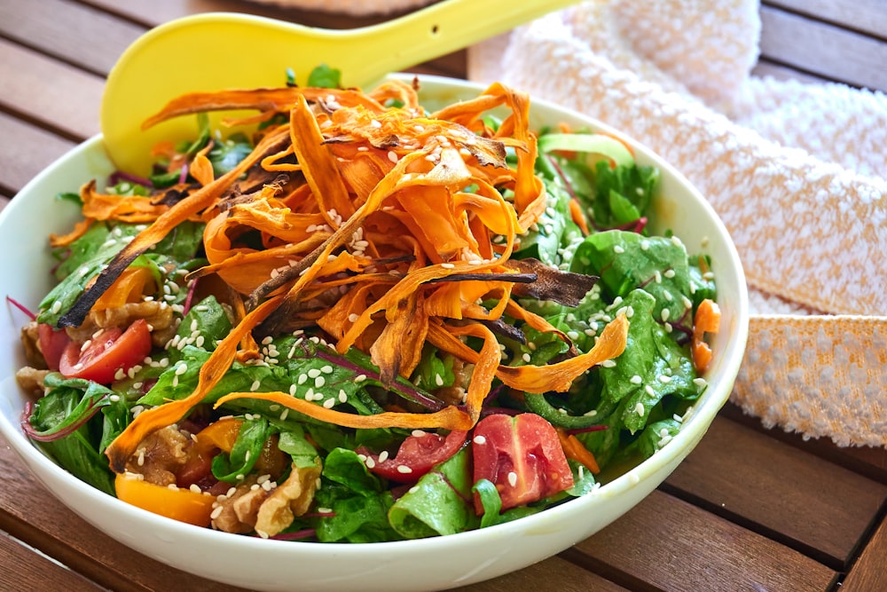 green and orange vegetable salad on white ceramic bowl