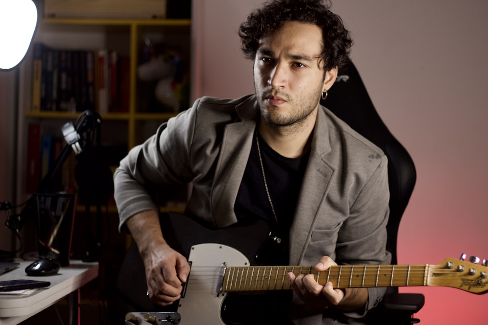 man in black leather jacket playing guitar