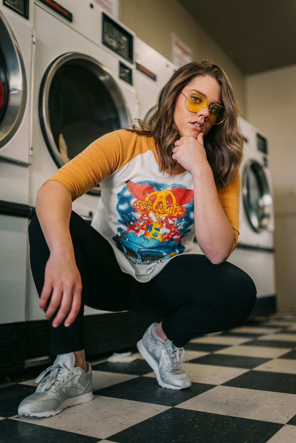 woman in white crew neck t-shirt and black pants sitting on black and white stairs