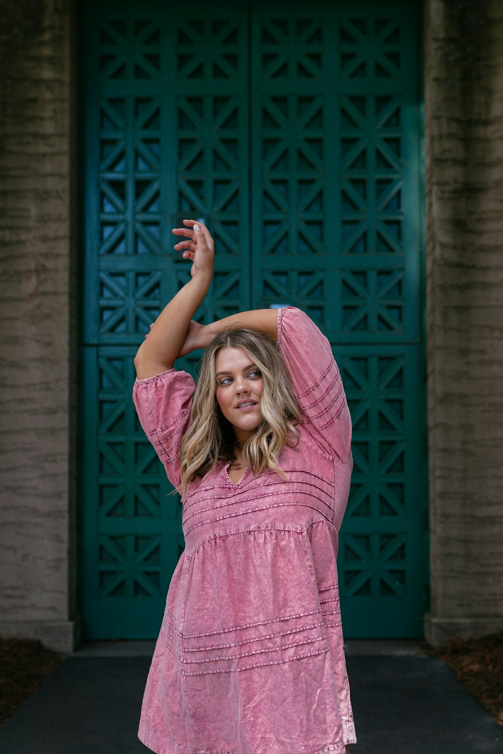 woman in pink and white stripe long sleeve shirt raising her hands