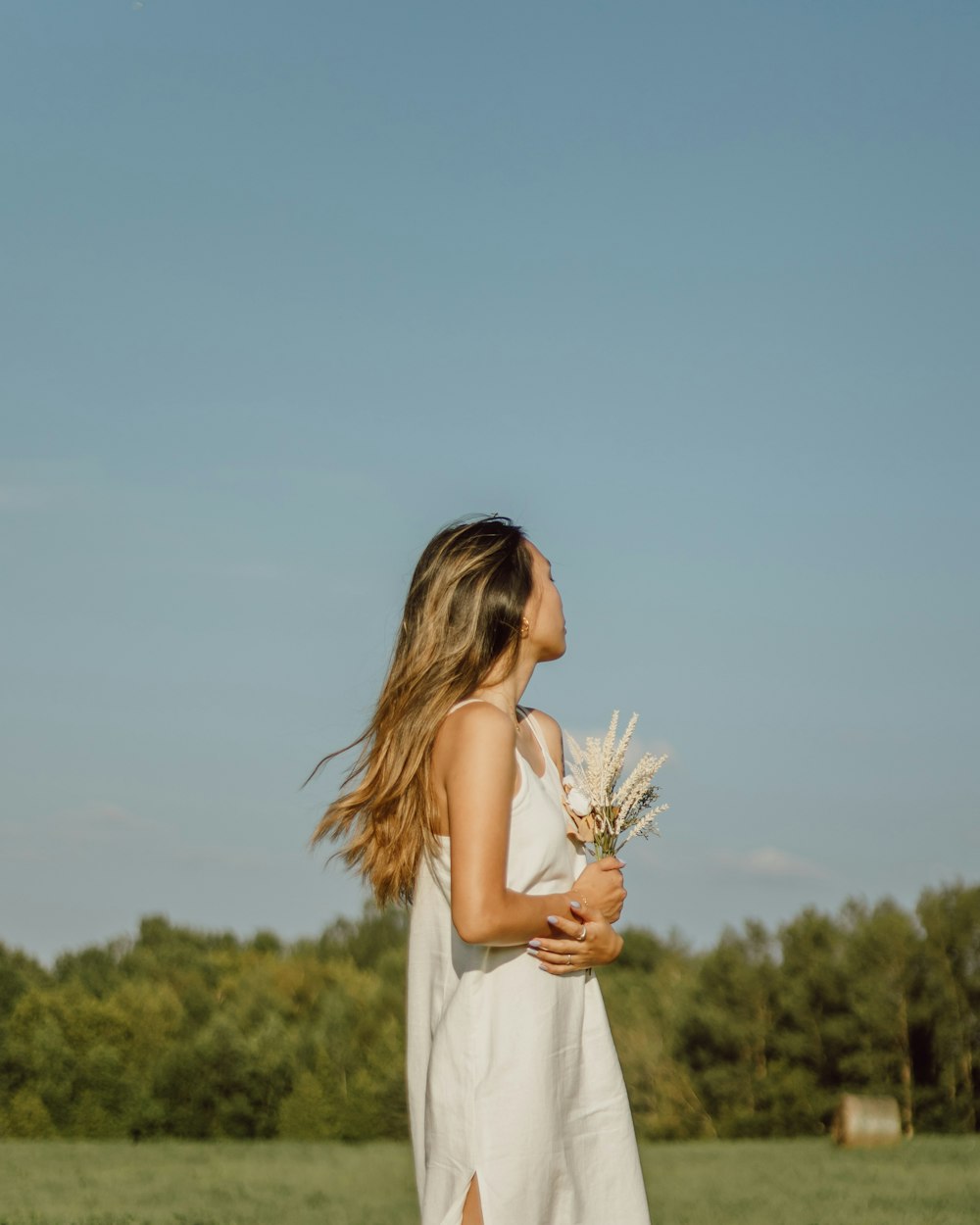 woman in white dress holding white flower