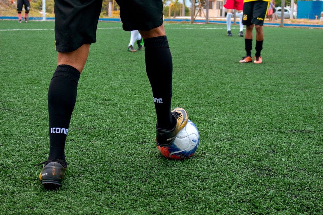 person in black and white nike soccer jersey kicking soccer ball