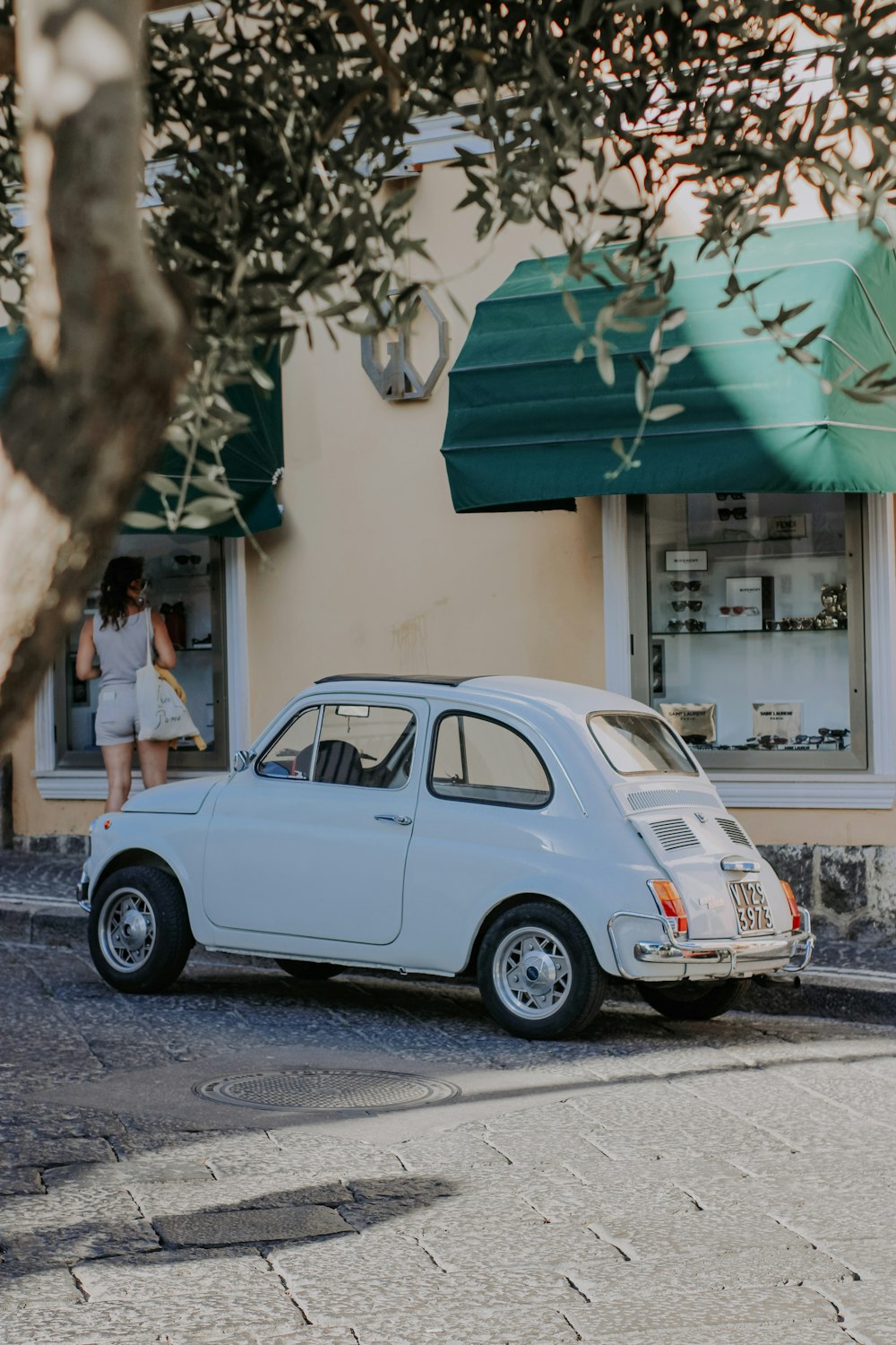 blue volkswagen beetle parked on sidewalk during daytime