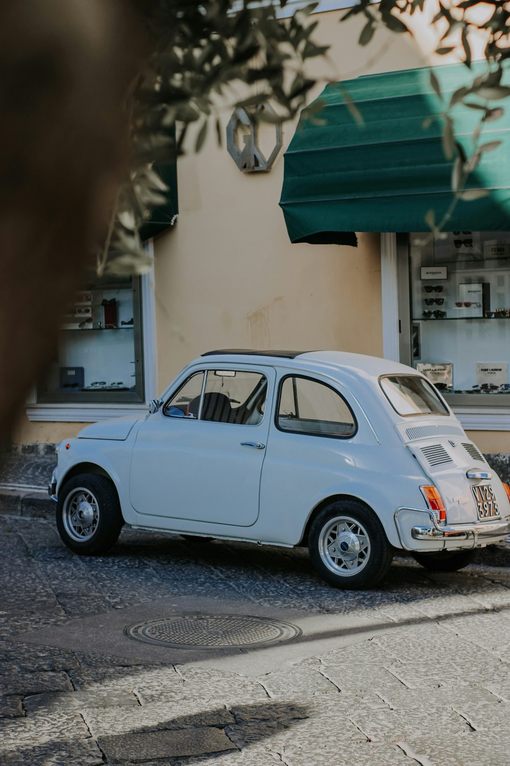 white volkswagen beetle parked beside white concrete building during daytime