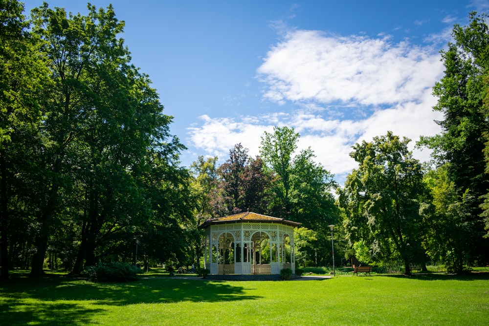 Casa bianca e marrone circondata da alberi verdi sotto il cielo blu durante il giorno