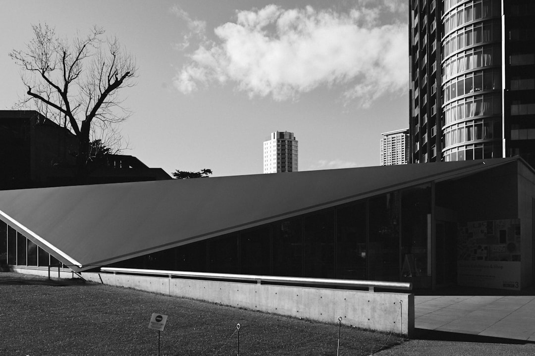 grayscale photo of building near trees