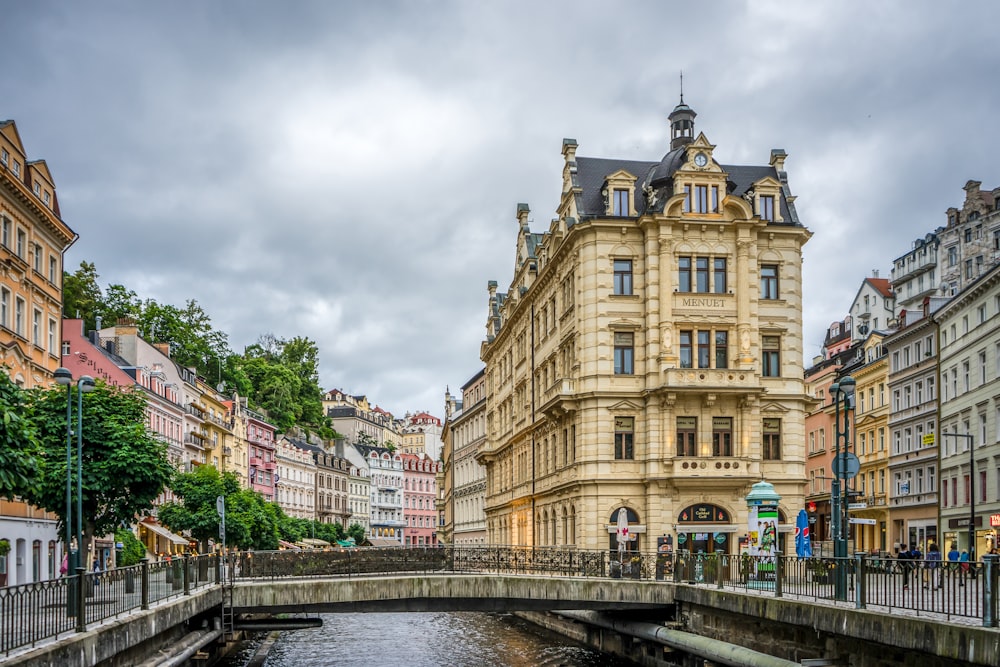 brown concrete building near bridge under white sky during daytime