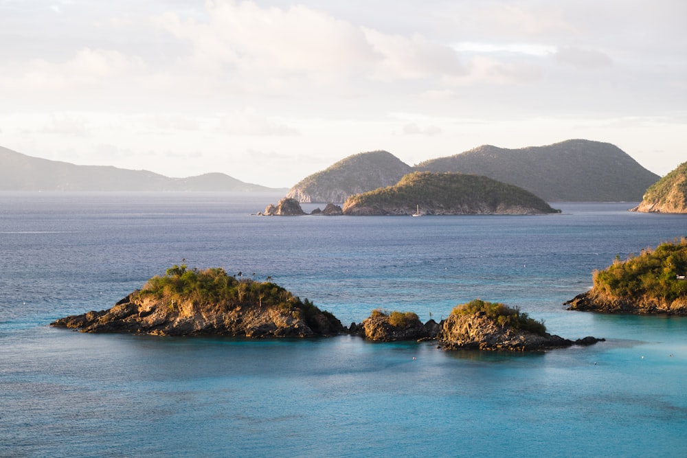 brown and green island on blue sea under white clouds during daytime