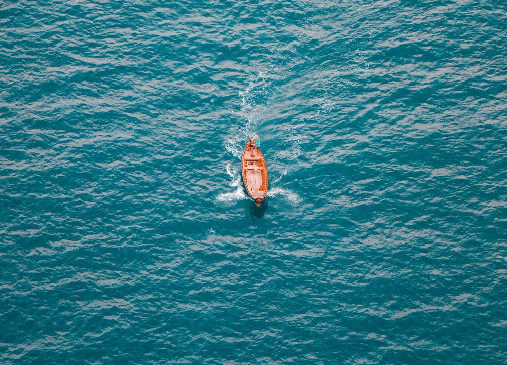 brown and white boat on body of water during daytime