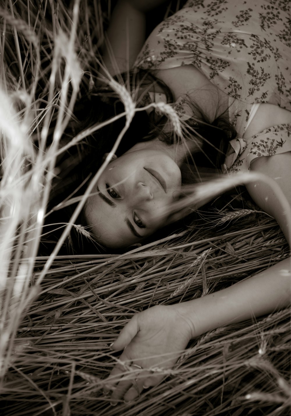 woman in white floral brassiere lying on brown dried grass