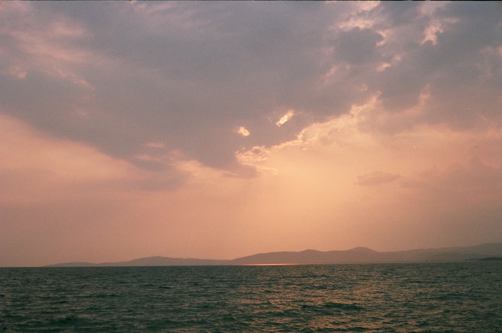 body of water under cloudy sky during daytime