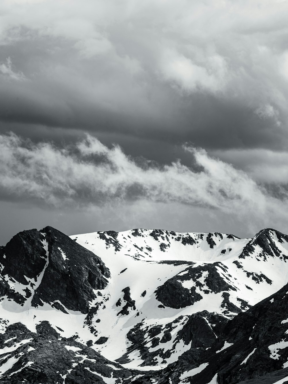 snow covered mountain under cloudy sky