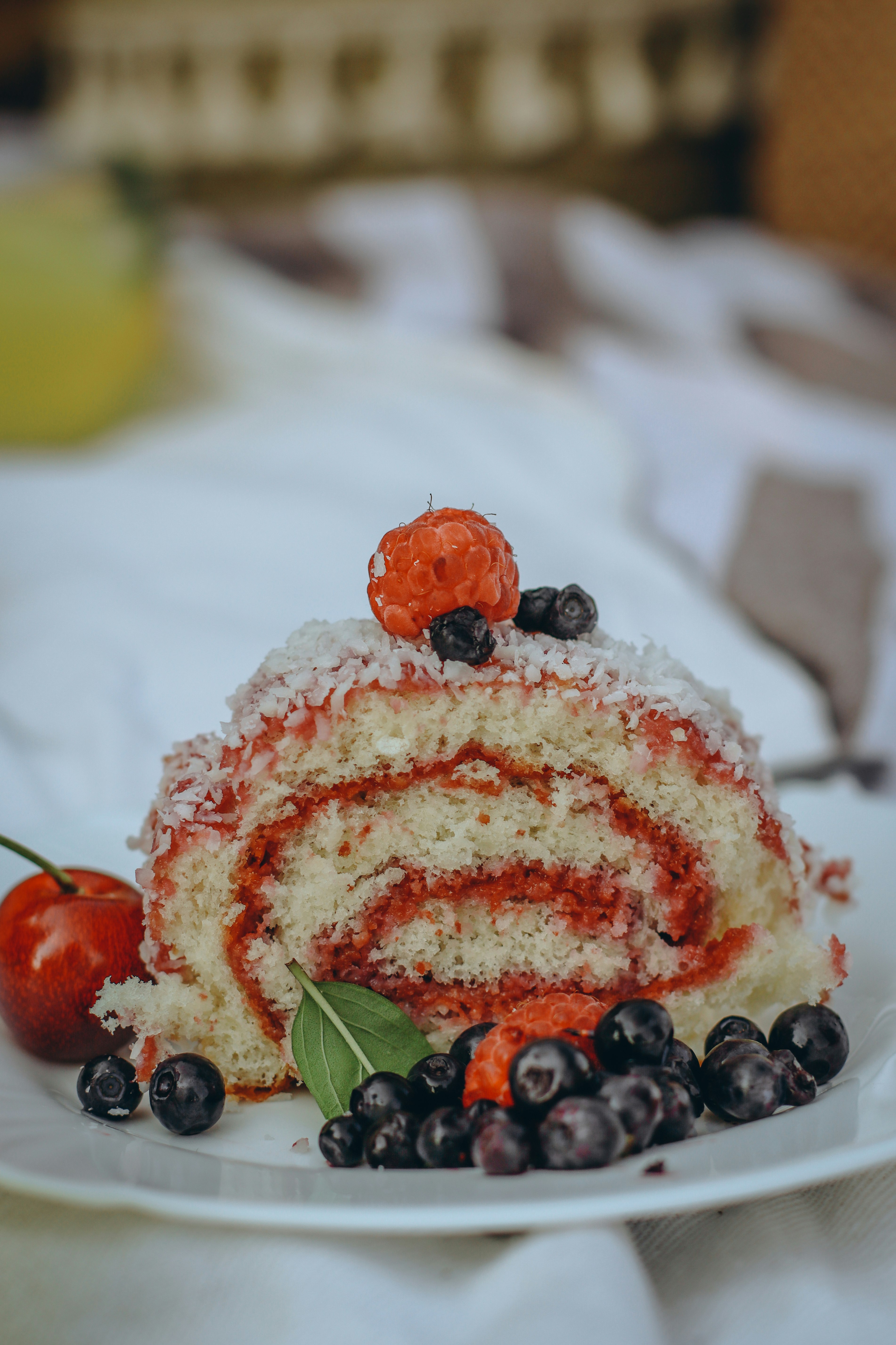 white and red cake with fruits on top