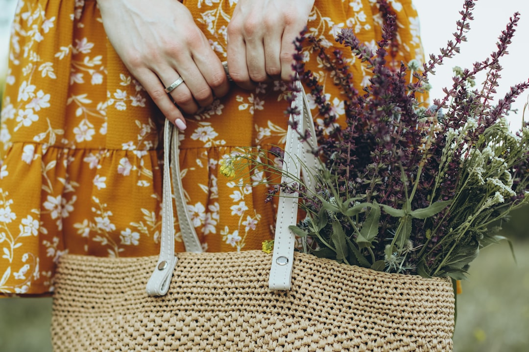 person holding brown and white tote bag