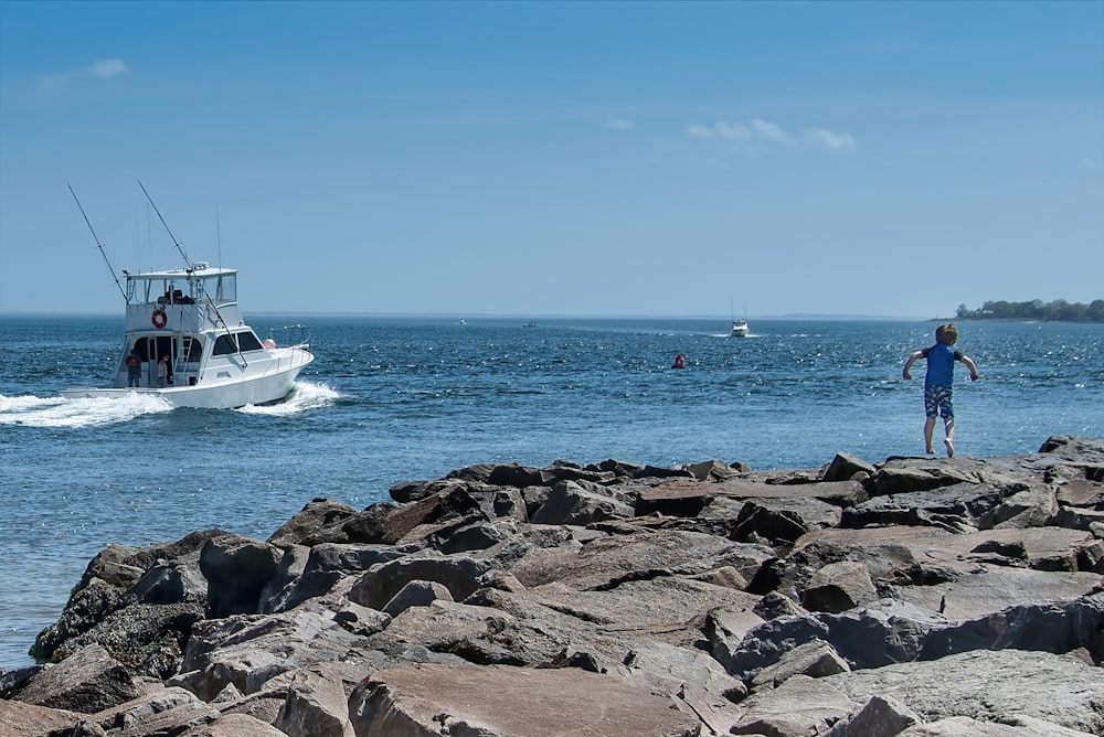 white boat on sea shore during daytime