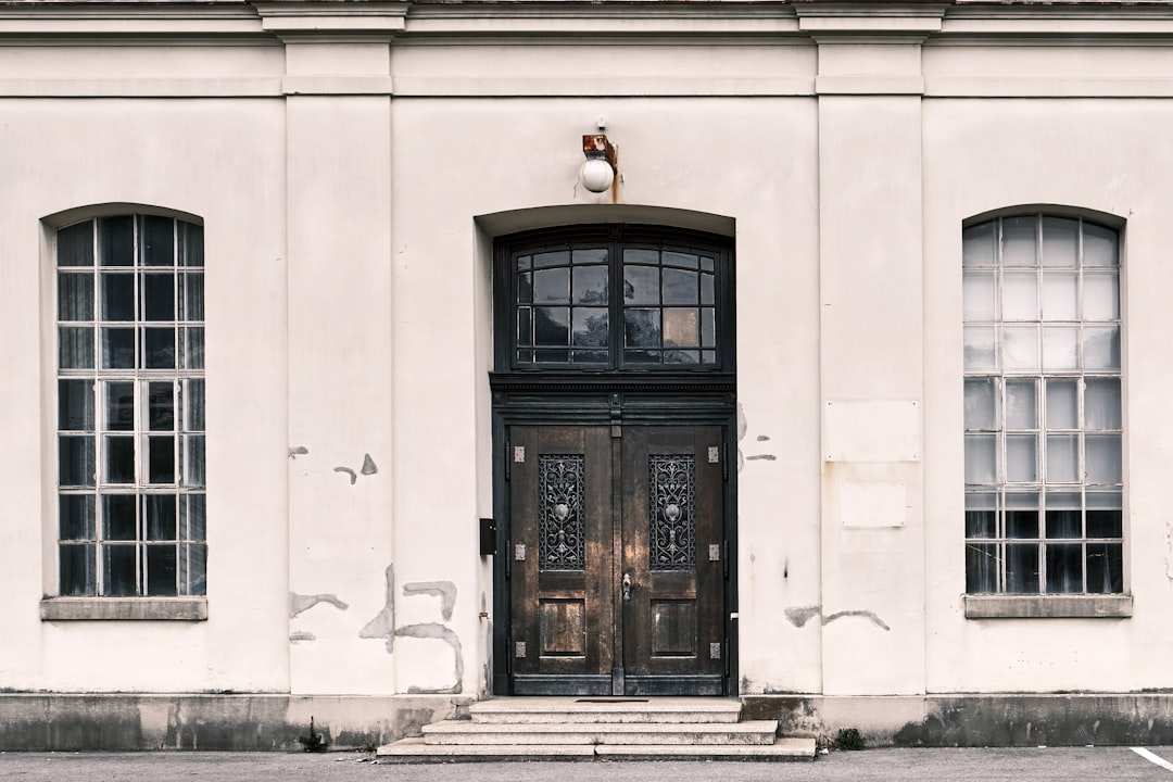 black wooden door on white concrete building