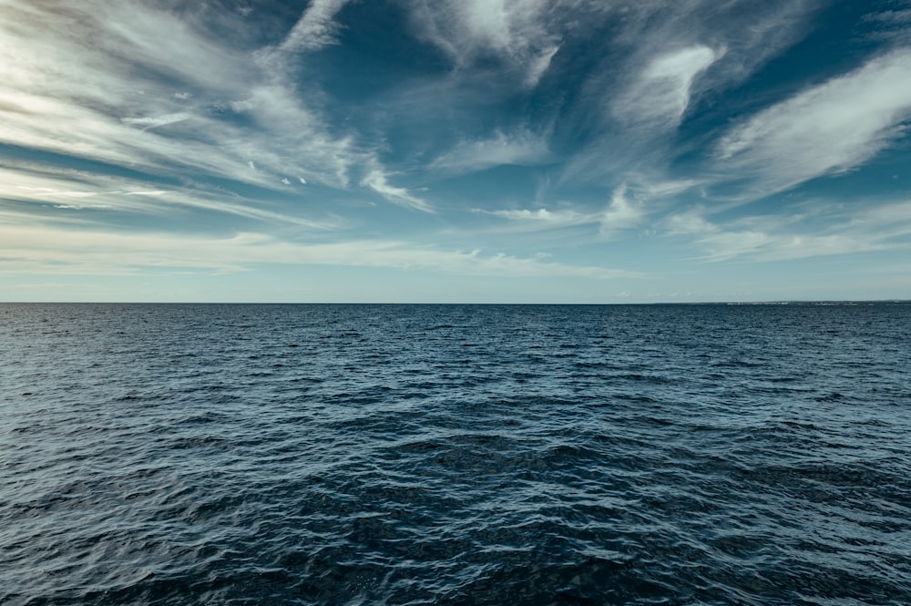 blue ocean under blue sky and white clouds during daytime