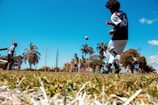 man in black and white jersey shirt and black pants playing soccer during daytime