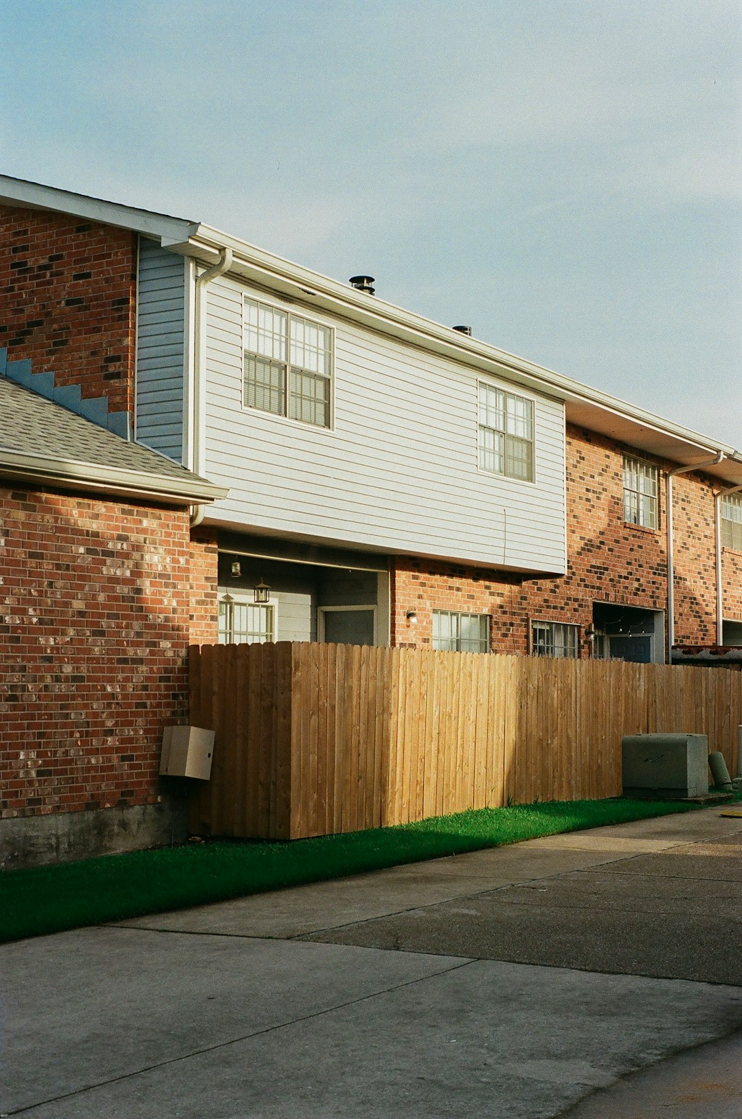 brown brick house with green grass lawn