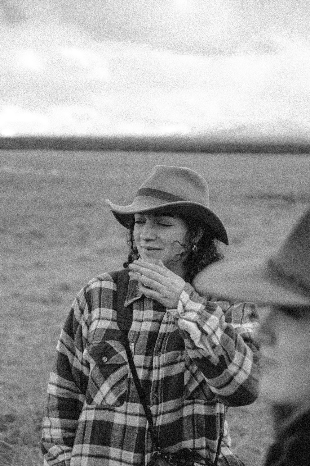 grayscale photo of man wearing hat and plaid shirt