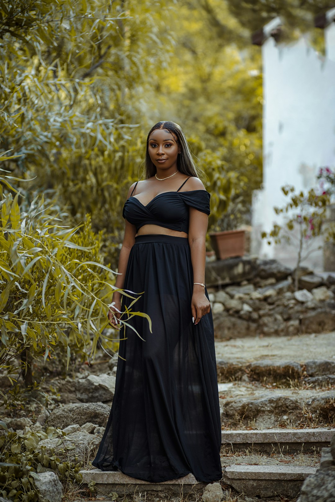 woman in black sleeveless dress standing on brown grass field during daytime