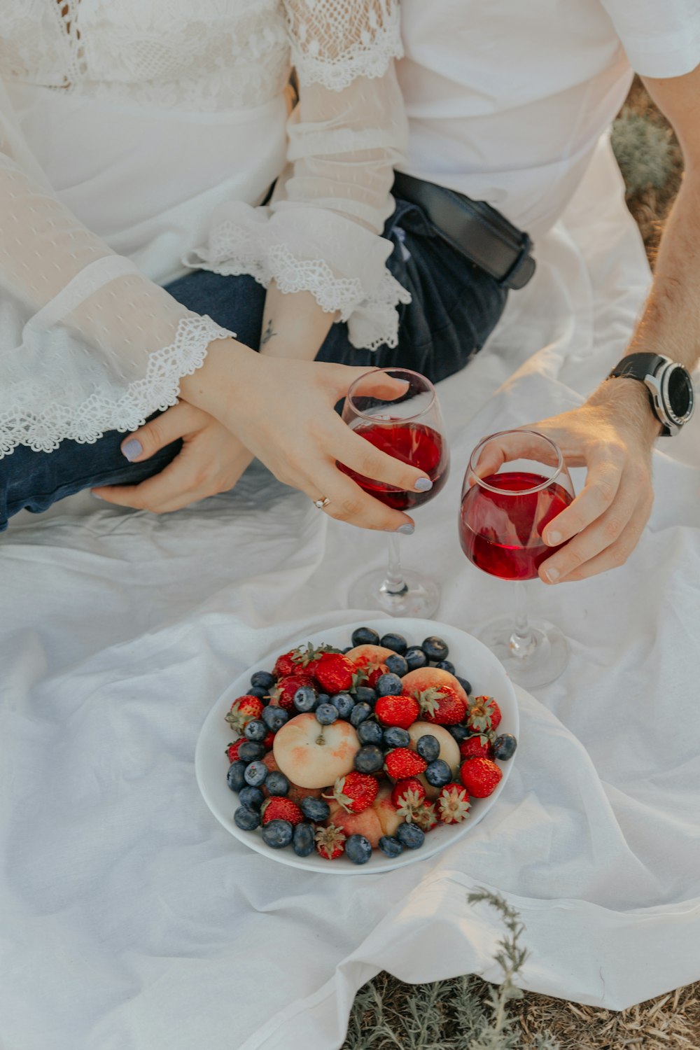 woman in white floral dress holding red and white round bowl with berries