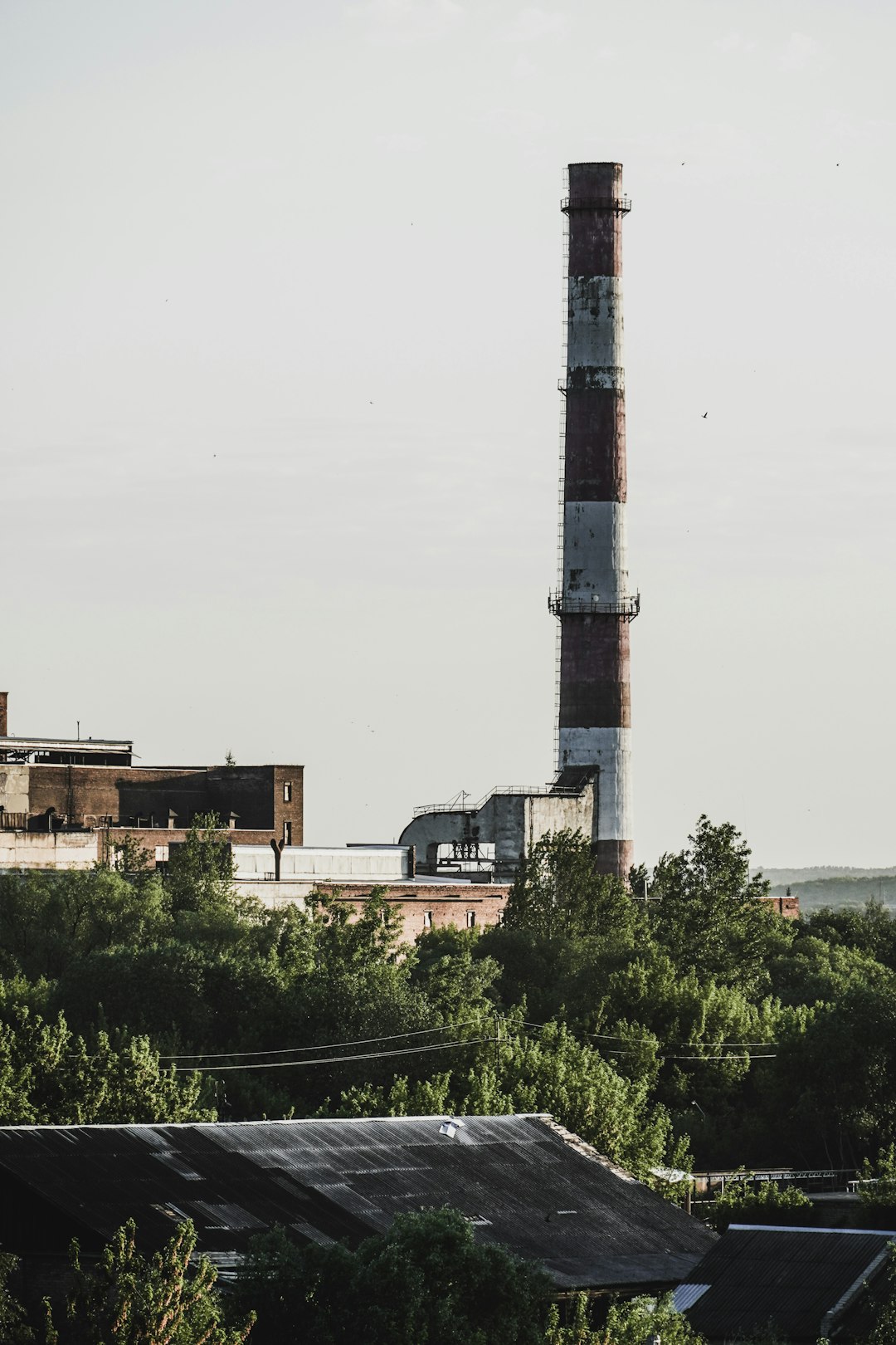 white and black tower near green trees under white sky during daytime