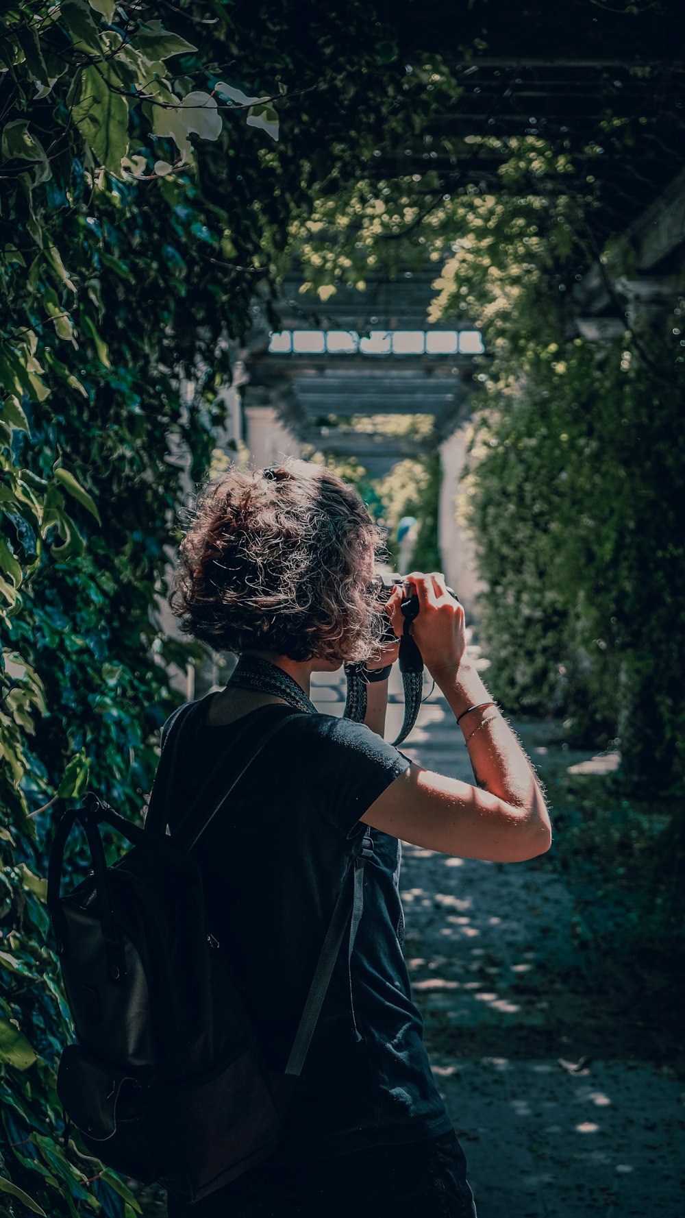 woman in black shirt standing near green plants during daytime