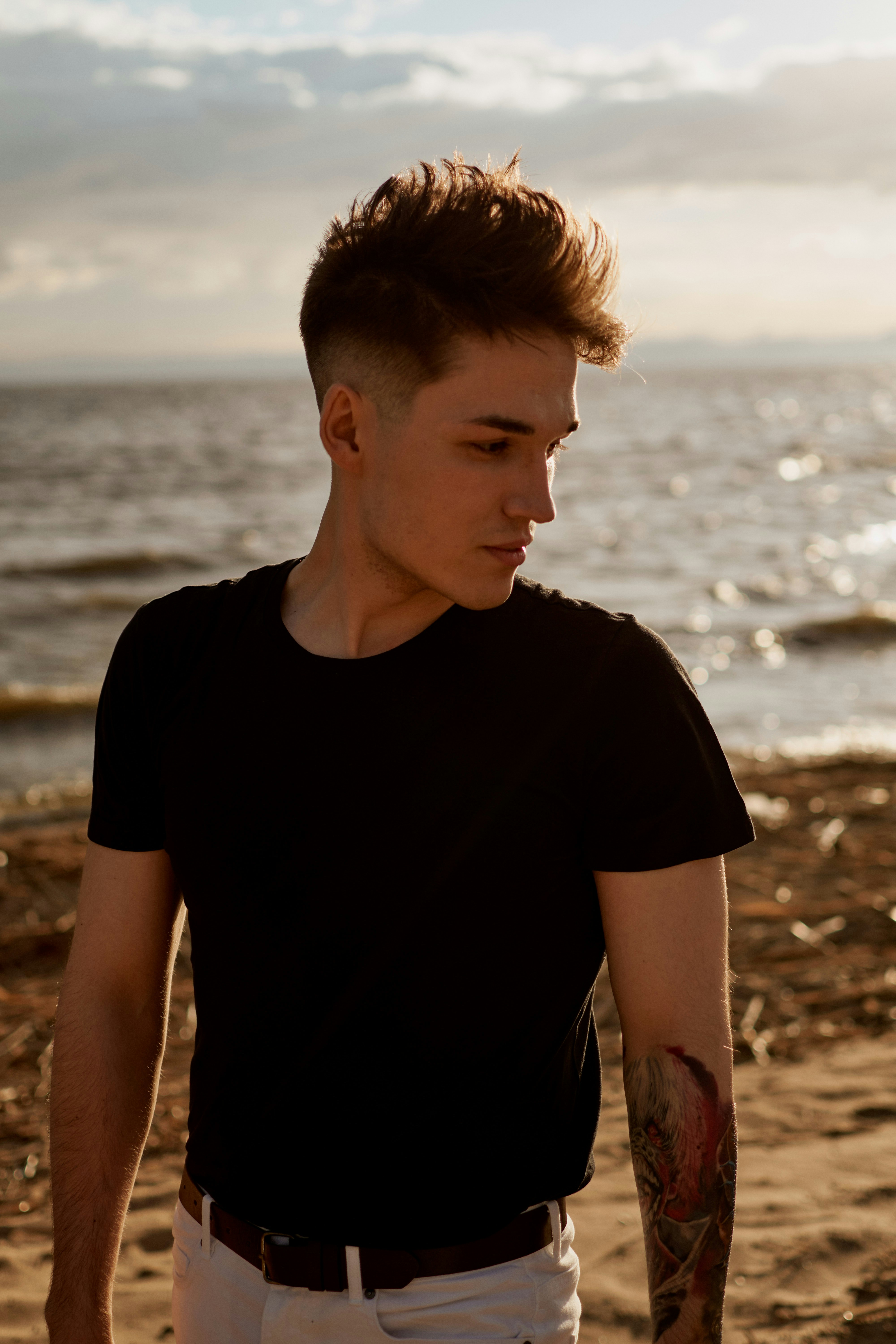 man in black crew neck t-shirt standing on beach during daytime