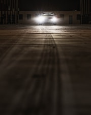 A shadowed studio space with subtle light playing over sleek CGI models of luxury cars and architectural forms.