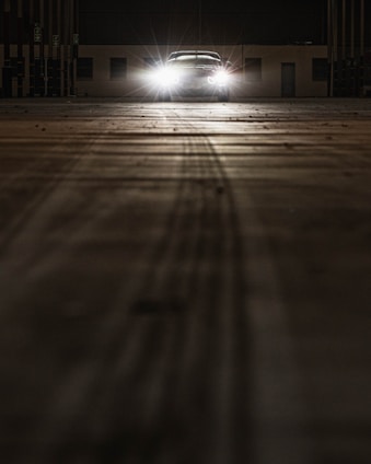 A shadowed studio space with subtle light playing over sleek CGI models of luxury cars and architectural forms.