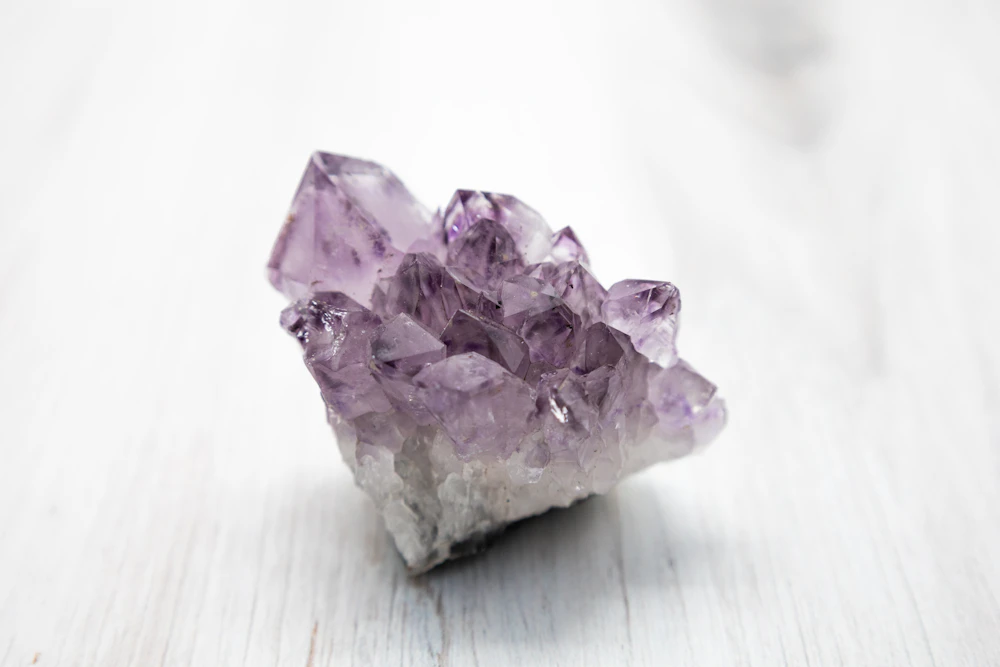 Purple crystal resting on a white table