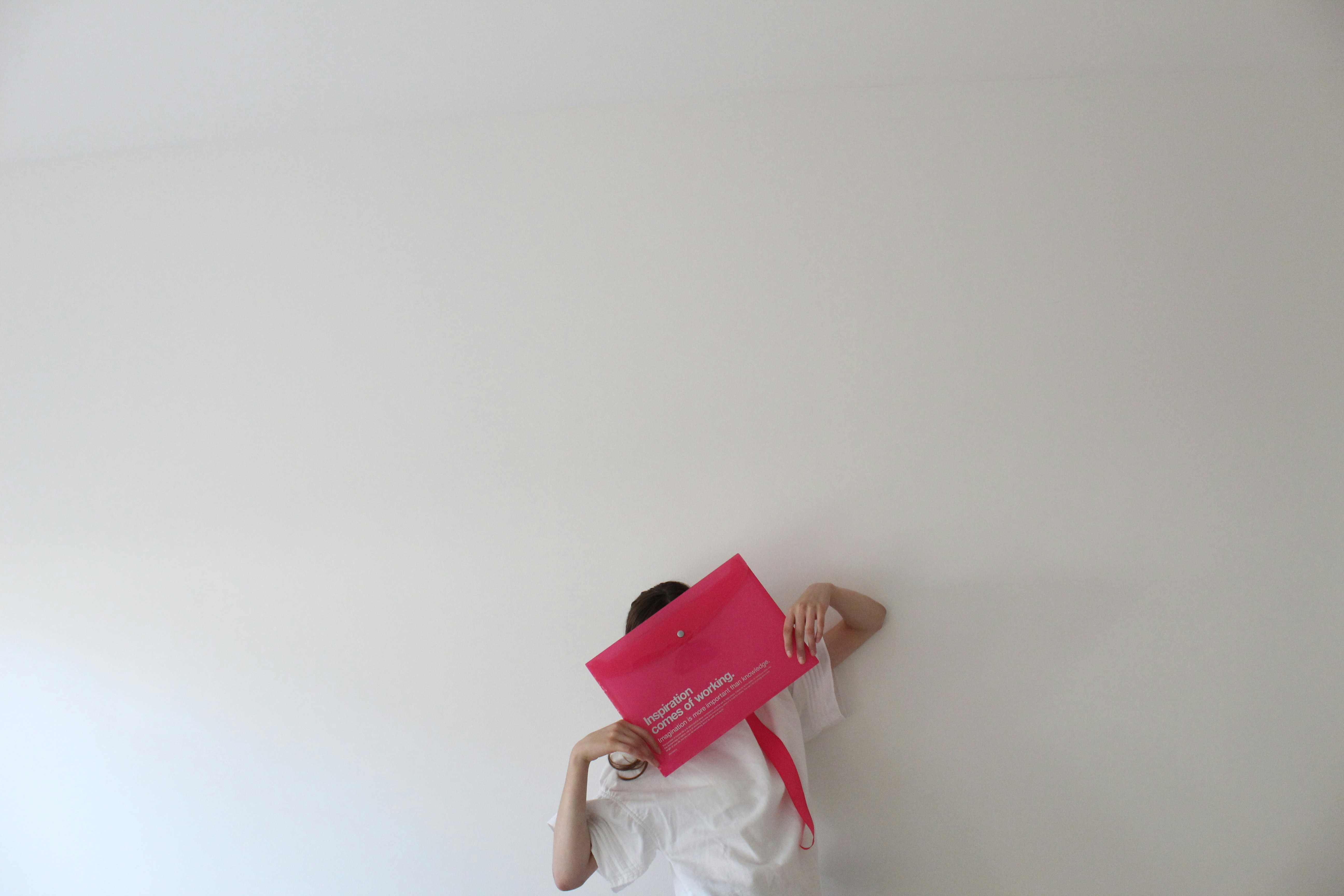 woman in white dress holding red book