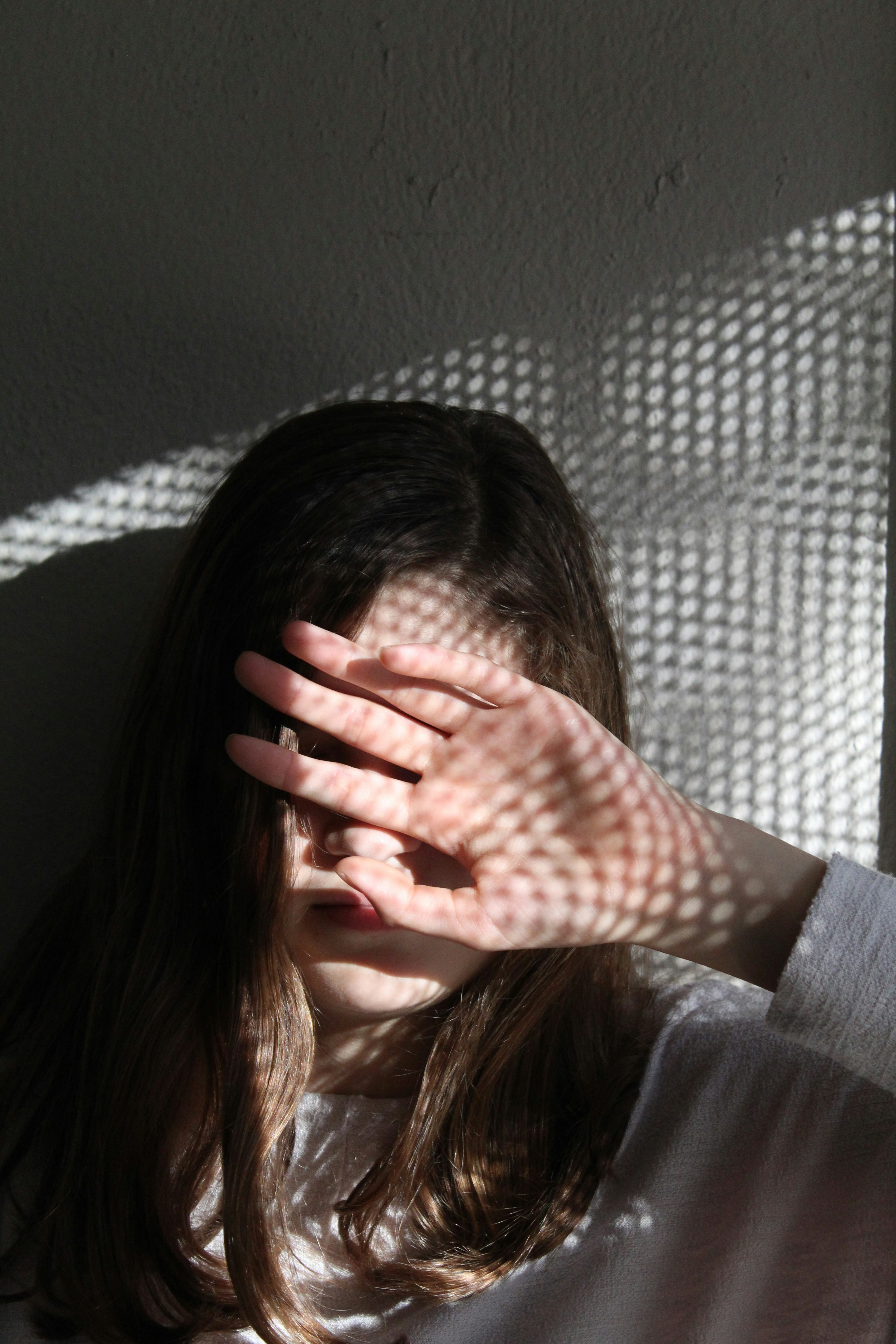 woman in black long sleeve shirt covering her face