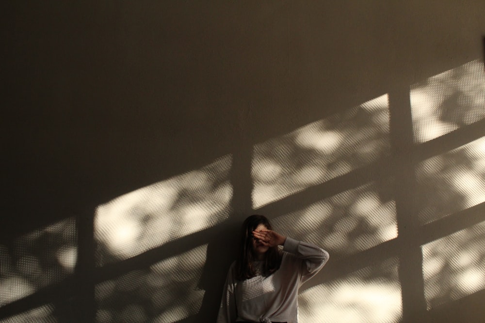 woman in white hijab standing beside white wall