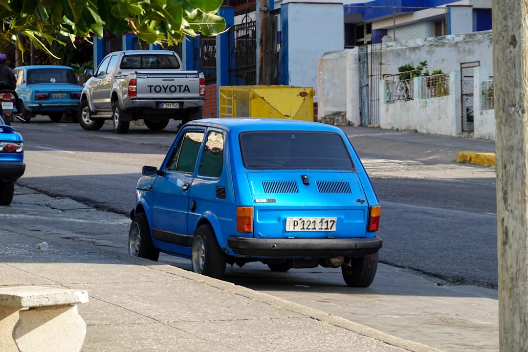 blue 5 door hatchback parked on sidewalk during daytime