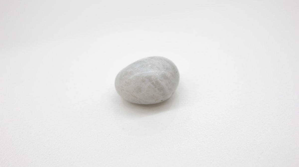 A small selection of polished healing crystals arranged on a clean white surface in soft natural light, ready for meditation or quiet reflection