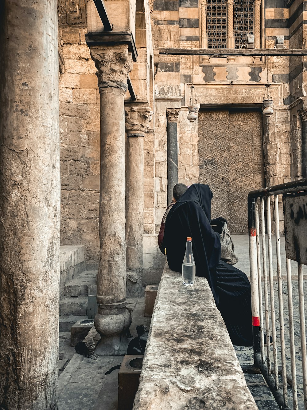 man in black jacket walking on gray concrete pathway during daytime