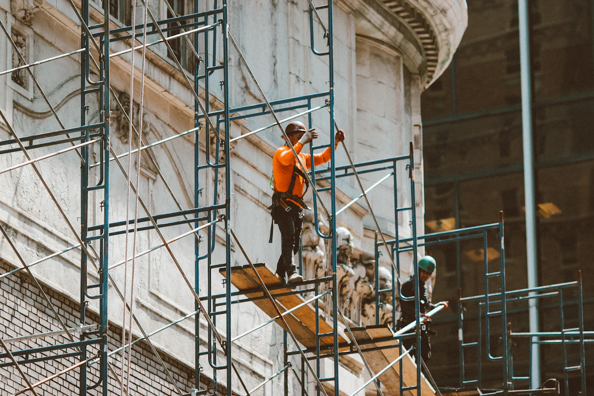 Operarios subiendo por una escalera en obra