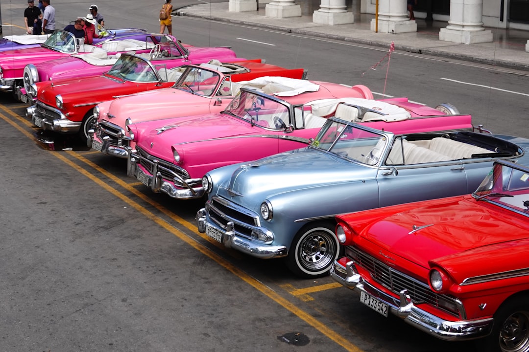 red and white vintage car on road during daytime