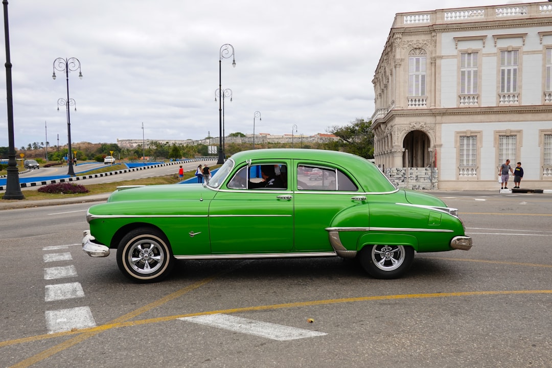 green vintage car on road during daytime