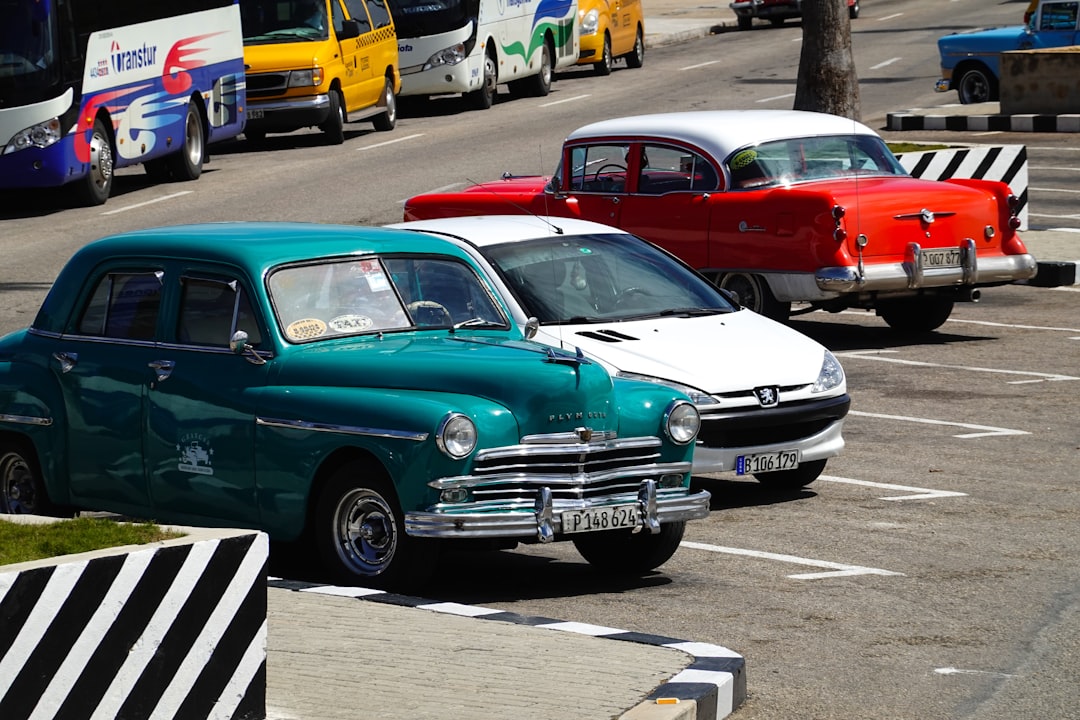 blue and white vintage car on parking lot during daytime