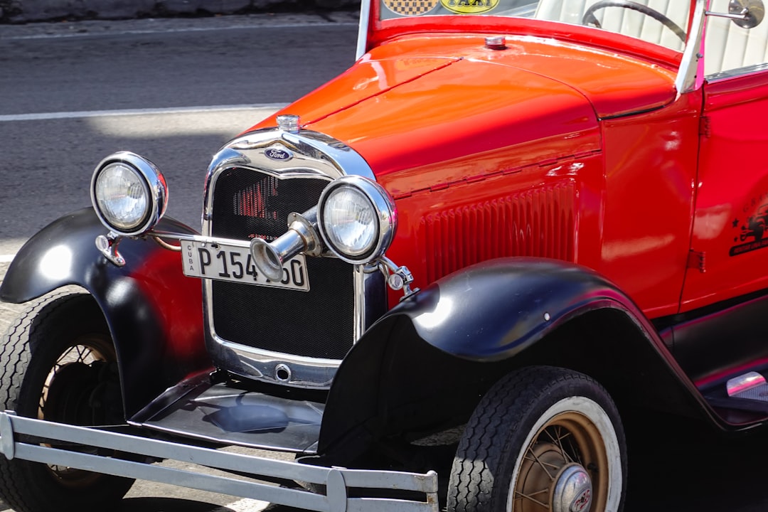 red vintage car on road during daytime