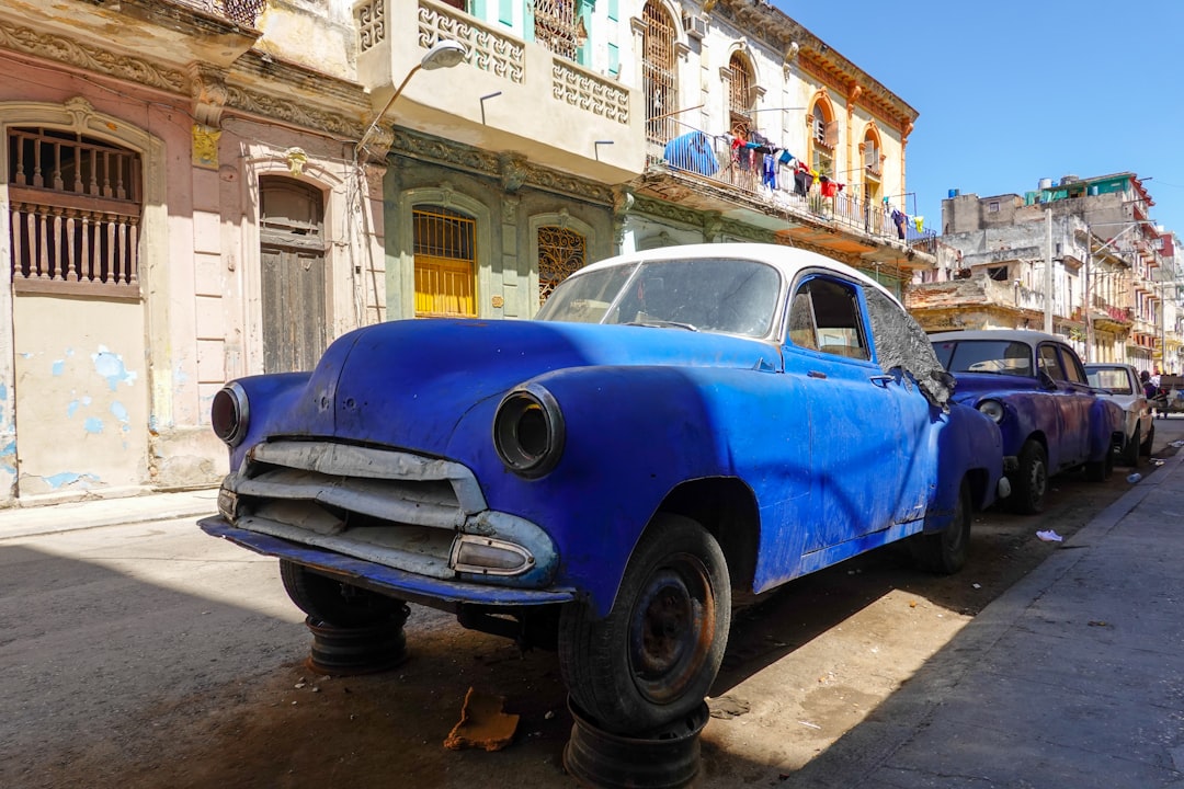 blue and white vintage car parked on sidewalk during daytime