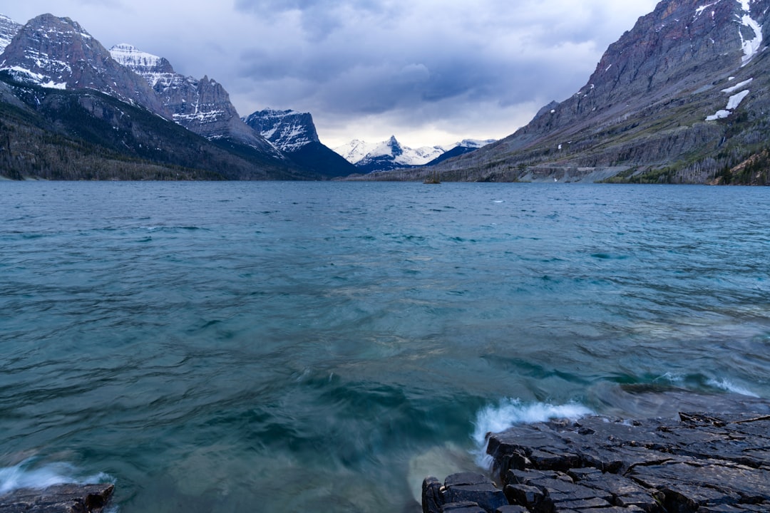 body of water near mountain during daytime