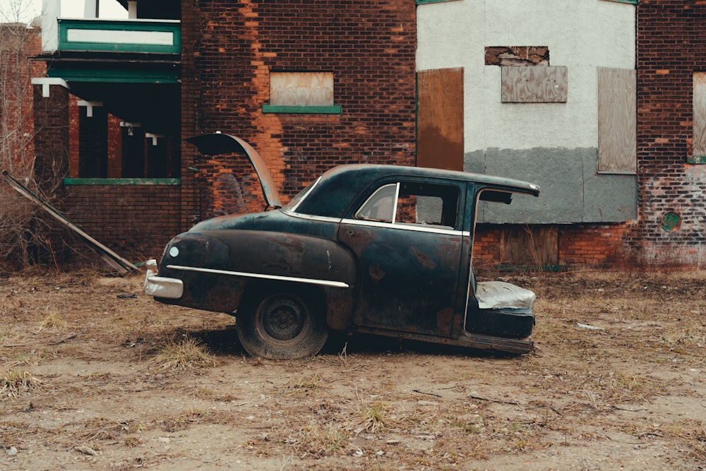 black classic car parked beside brown brick building