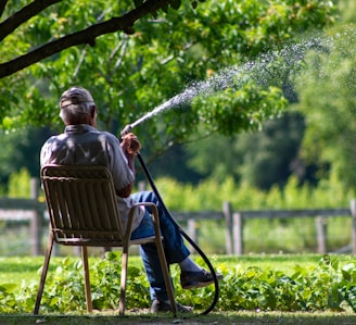 man in blue and white striped shirt sitting on brown wooden armchair