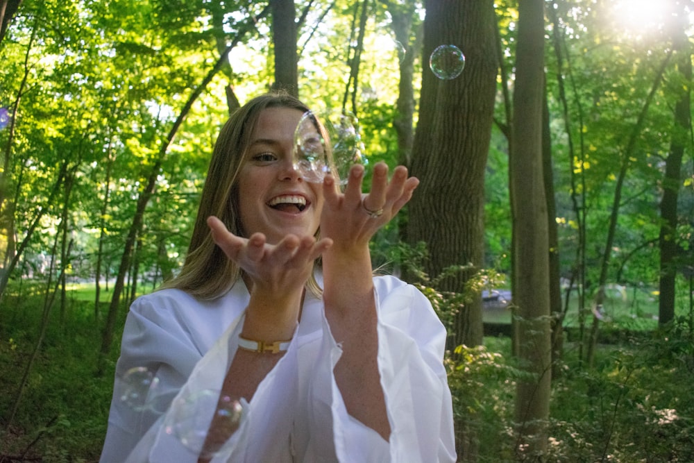 woman in white dress shirt covering her face with her hands