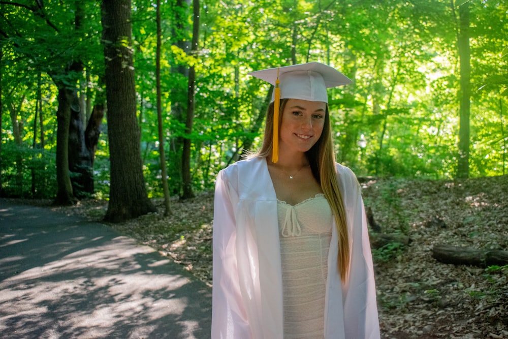 woman in white dress standing on forest during daytime