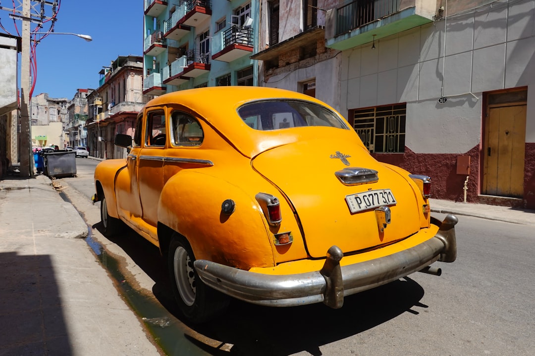 yellow and black volkswagen beetle parked on sidewalk during daytime
